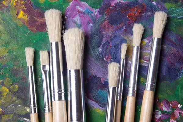 Close up of wooden paint brushes on oil paints — Stock Photo, Image