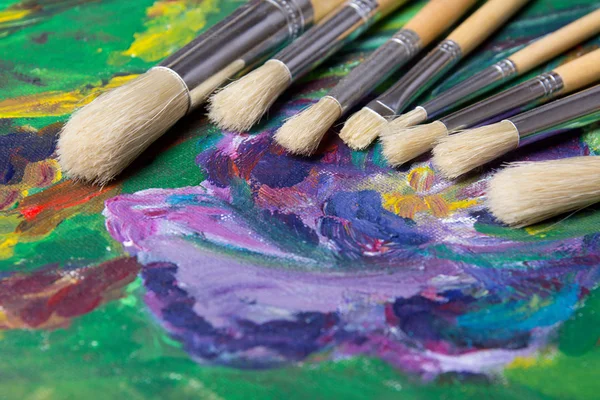 Close up of paint brushes on canvas background — Stock Photo, Image