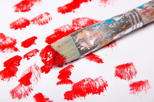 Pinceau avec les tracés de peinture rouge sur blanc — Photo