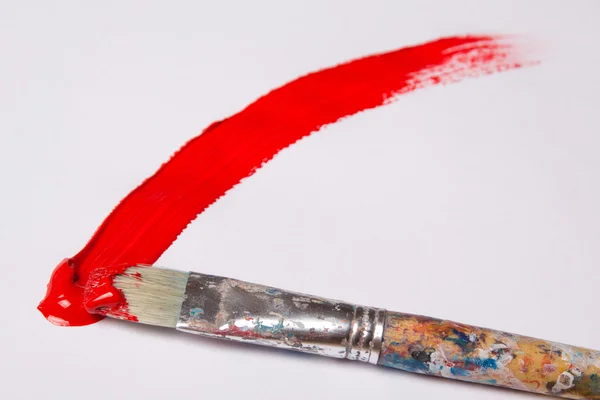Pincel com derrame tinta vermelha sobre branco — Fotografia de Stock