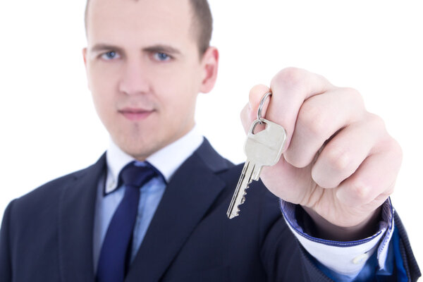 закройтесь металлического ключа в мужской руке агента по операциям с недвижимостью, изолированной на