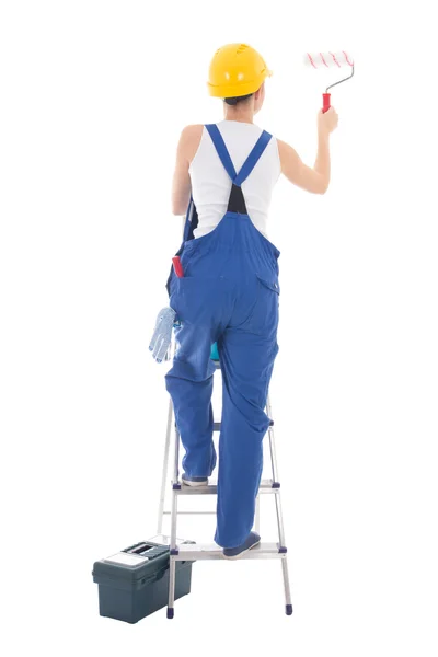 Back view of young woman painter in blue coveralls standing on l — Stock Photo, Image