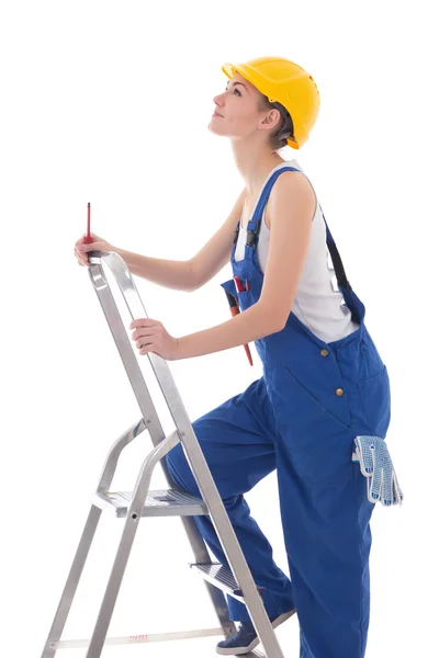 Young woman builder in blue coveralls with screwdriver on ladder — Stock Photo, Image