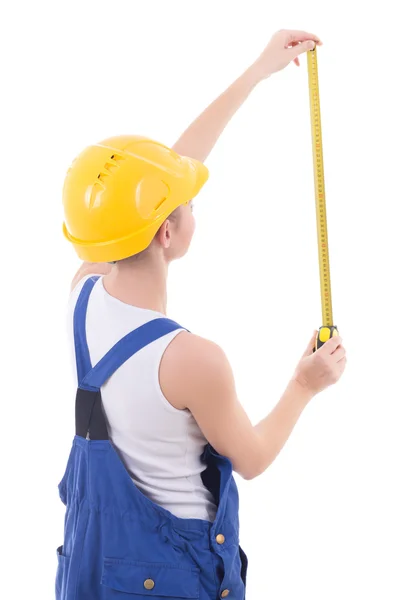 Vista posterior de constructor de mujer en guardapolvos azules medir algo —  Fotos de Stock