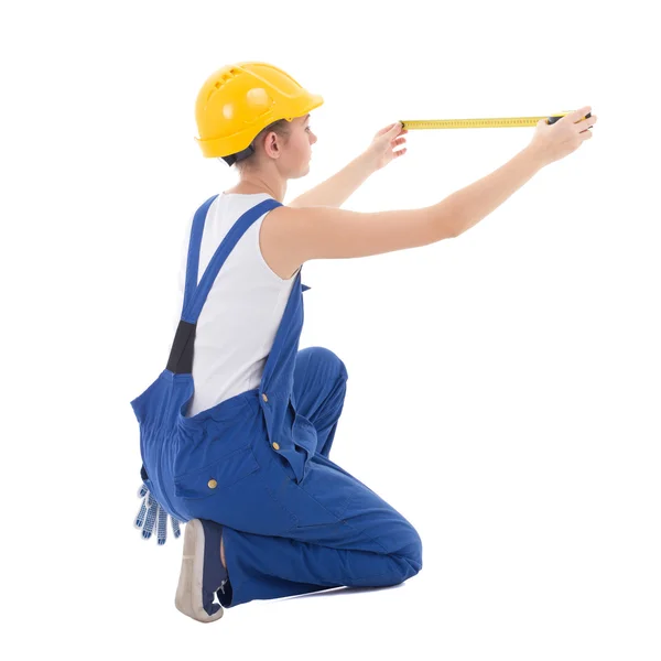 Back view of sitting woman builder in workwear measuring somethi — Stock Photo, Image
