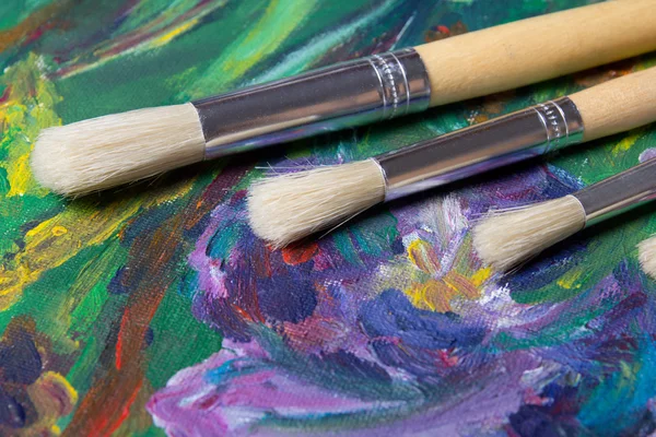 Close up of paint brushes on canvas background — Stock Photo, Image