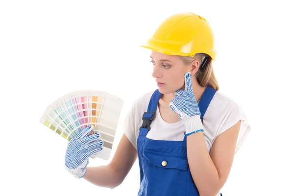 Young woman painter in blue builder uniform choosing color isola — Stock Photo, Image
