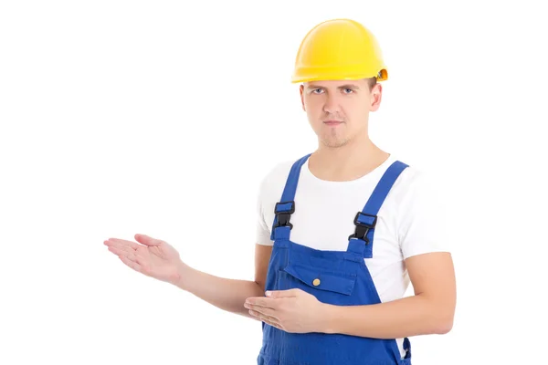 Man builder in blue uniform and helmet presenting something isol — kuvapankkivalokuva