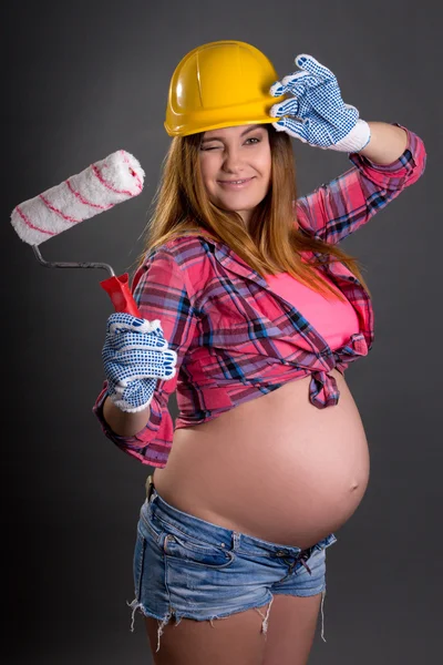 Drôle jeune belle femme enceinte dans le casque du constructeur avec p — Photo