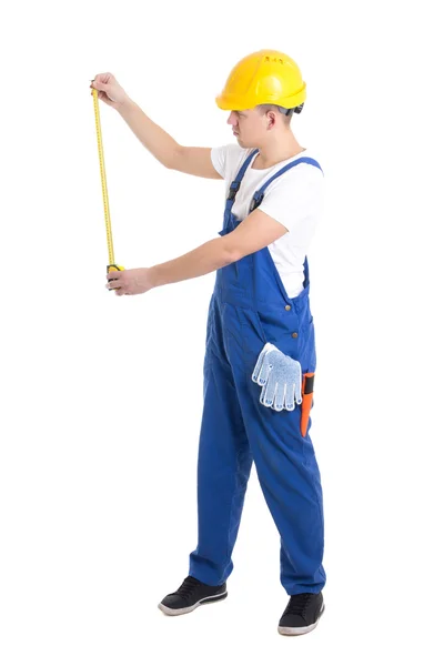 Side view of man builder in blue coveralls holding measure tape — Stock Photo, Image