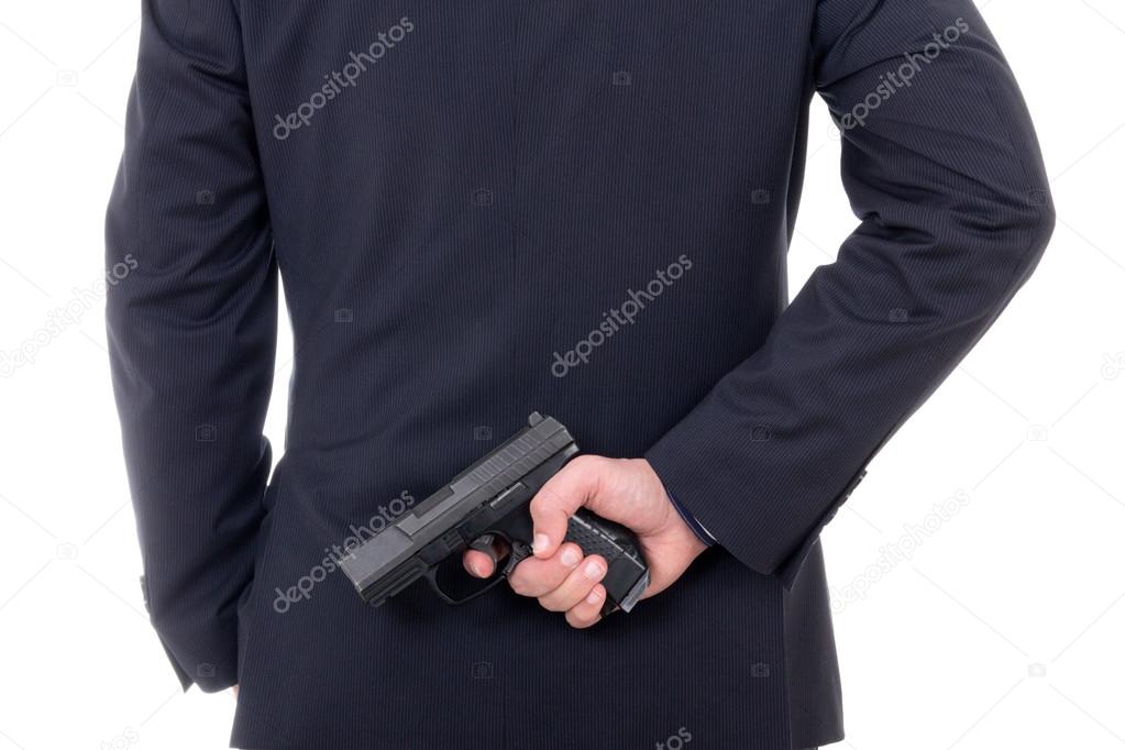 man hiding gun behind his back isolated on white
