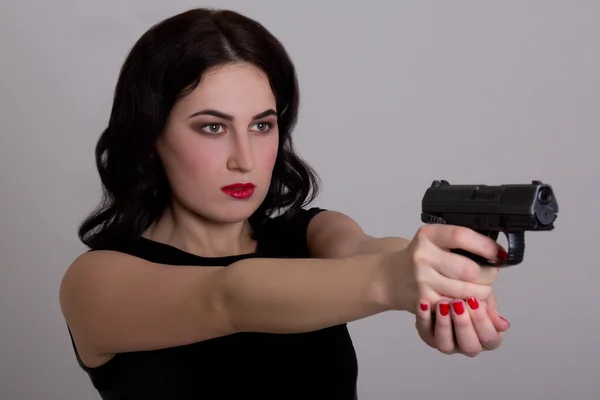 Allvarliga sexig tjej skjuta med pistol isolerad på vit — Stockfoto