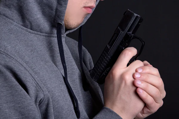 Zár-megjelöl-ból fegyver a férfi kezében felett szürke — Stock Fotó