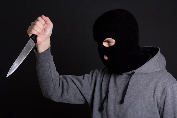 Mann-Verbrecher in schwarze Maske mit Messer über grau — Stockfoto