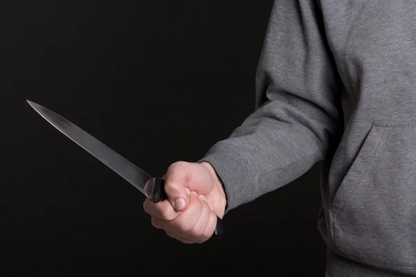 Cierre para arriba del cuchillo en la mano masculina sobre gris — Foto de Stock