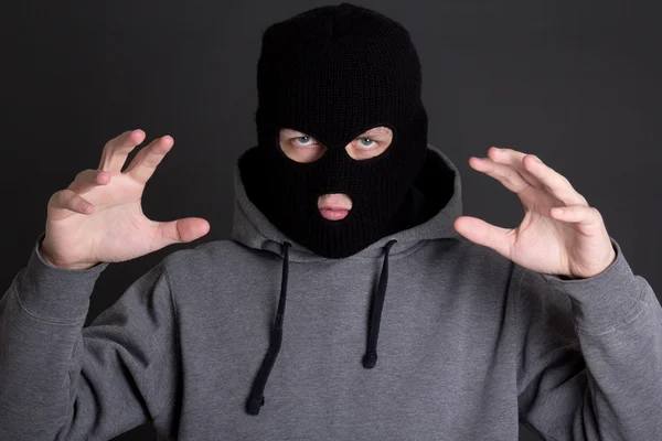 Angry man criminal in black mask over grey — Stock Photo, Image