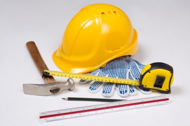 Builder'ın iş araçları ve sarı kask beyaz üzerinde kapat