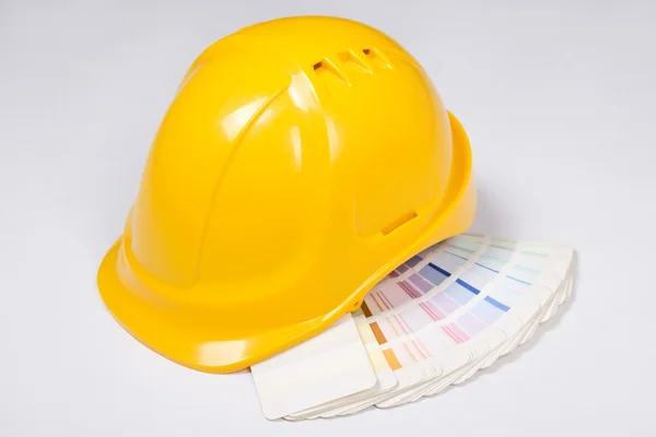De constructor casco amarillo y paleta de color sobre blanco —  Fotos de Stock