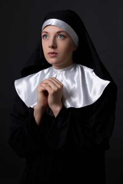 Concepto de religión - joven monja rezando sobre gris — Foto de Stock