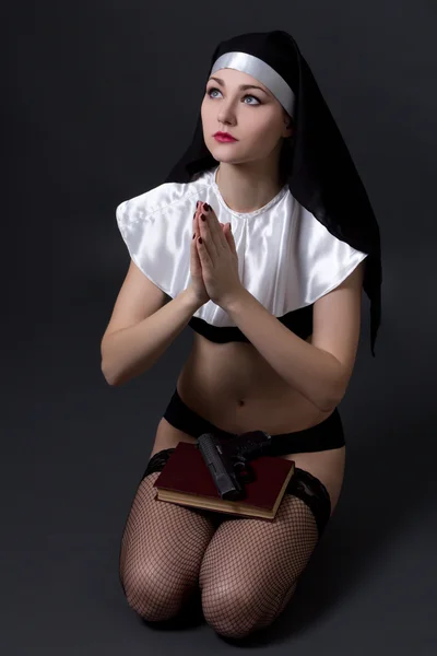 Beautiful sexy woman nun in lingerie praying with bible and gun — Stock Photo, Image