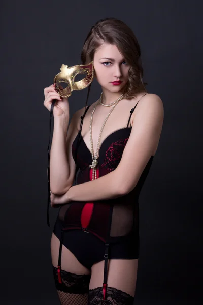 Jonge mooie sexy vrouw in lingerie poseren met masker over gre — Stockfoto