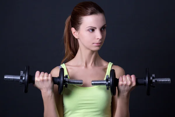 Retrato de joven bella mujer deportiva con mancuernas sobre gre —  Fotos de Stock