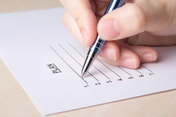 Female hand filling plan list with pen — Stock Photo, Image