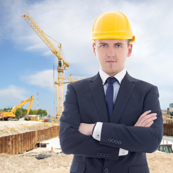 portrait of young handsome business man in builder's helmet