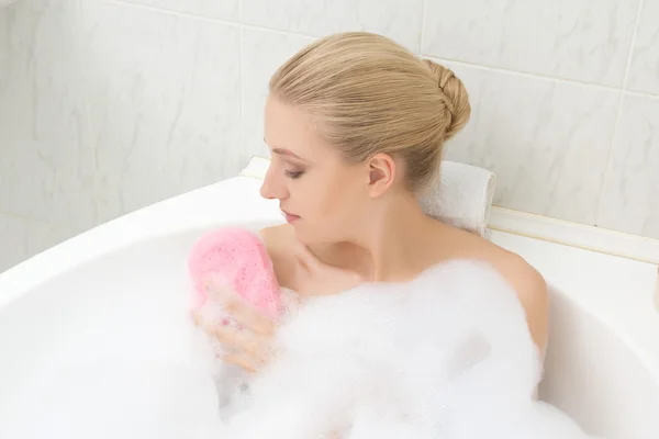 Woman relaxing in bath and washing herself — Stock Photo, Image