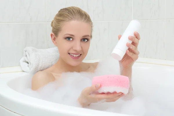 Hermosa mujer en el baño con esponja y gel de ducha — Foto de Stock