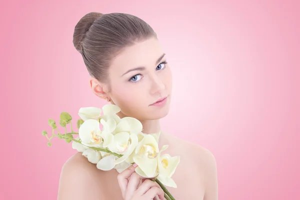 Portrait of young beautiful woman with orchid flower over pink — Stock Photo, Image