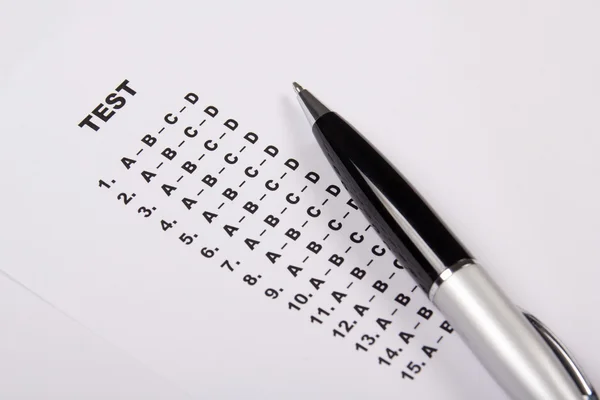 Feuille de match de test avec des réponses et stylo — Photo