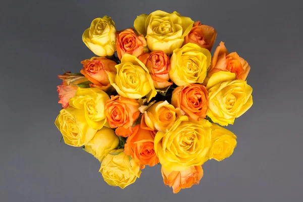 Beau bouquet de roses jaunes et oranges sur gris — Photo