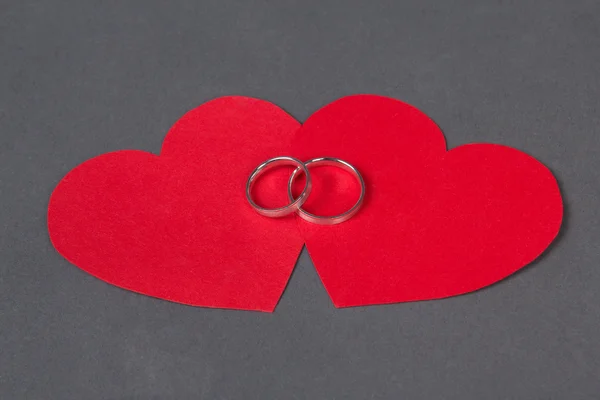 Anillos de boda corazón rojo sobre gris — Foto de Stock