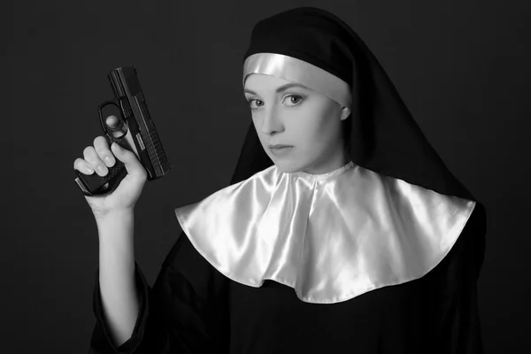 Black and white portrait of woman nun with gun — Stock Photo, Image