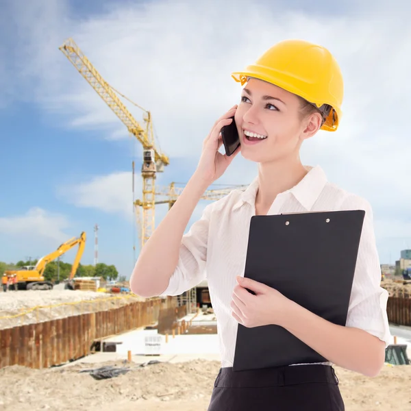 Beautiful business woman architect in builder helmet talking by — Stock Photo, Image