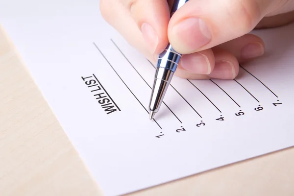 Close up van vrouwelijke hand schrijven van haar wens-lijst — Stockfoto