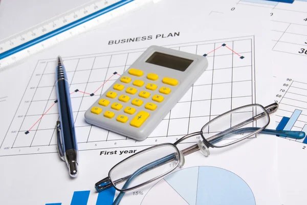 Business papers with graphs, charts, glasses, pen and calculator — Stock Photo, Image