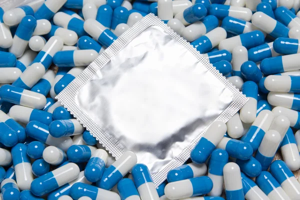 Close up of condom and blue pills — Stock Photo, Image