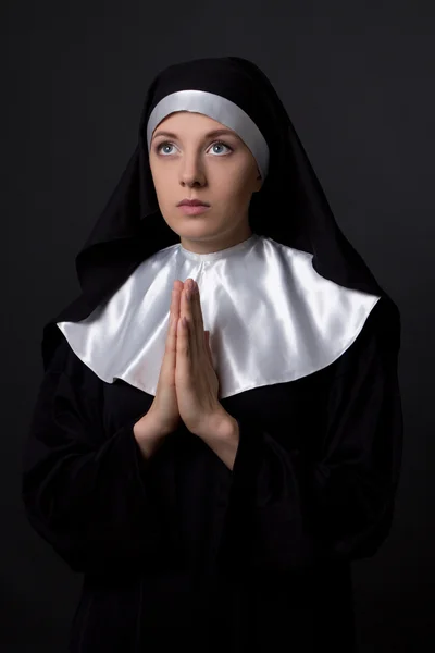 Concept de religion - jeune nonne priant sur gris — Photo