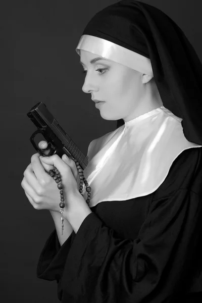 Svartvita porträtt av kvinnan nunna håller gun — Stockfoto