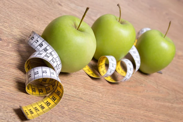 Diet concept - close up of green apples and measure tape on tabl — Stock Photo, Image