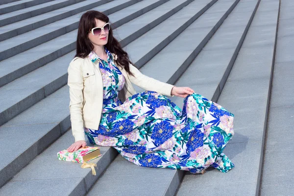 Привлекательная женщина в платье, сидя на каменной лестницы — стоковое фото