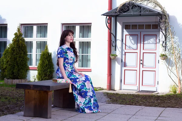 Hermosa mujer en vestido sentado en el Banco de la ciudad vieja de Tal — Foto de Stock