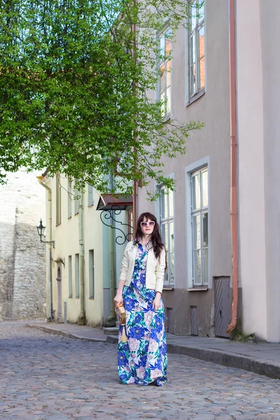 Ung kvinna i lång klänning promenader i gamla stan i Tallinn — Stockfoto