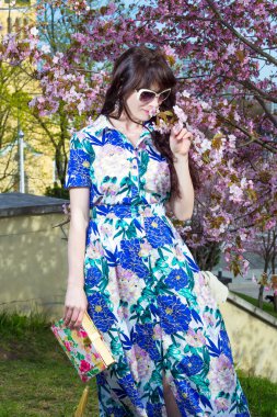 güzel kadın parkta blooming sakura ağacı üzerinde poz