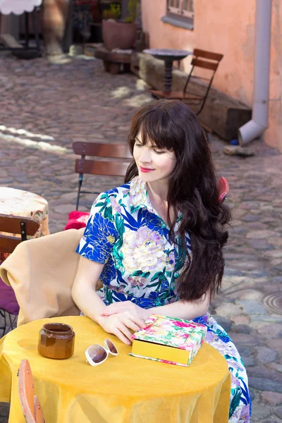 Hermosa mujer en vestido sentado en la cafetería de verano —  Fotos de Stock