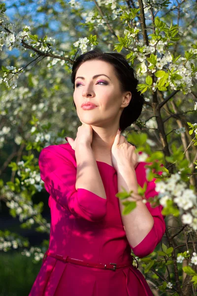 Portret van een jonge vrouw poseren in de bloeiende tuin — Stockfoto