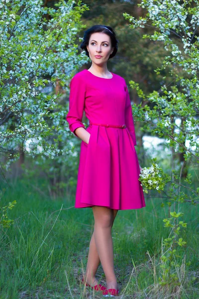 Hermosa mujer caminando en el jardín de flor de cerezo — Foto de Stock