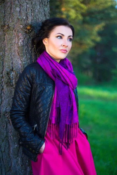 Hermosa mujer de pie cerca del árbol en el bosque de la primavera — Foto de Stock